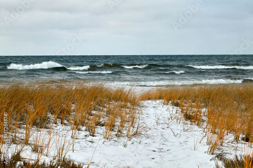Stormy lake and snow covered winter shoreline