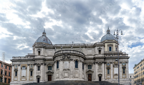 Facade of the papal Basilica called Santa Maria Maggiore, without people in sight and with a blue sky with very light clouds. In the square called "Esquilino" in Rome, Italy