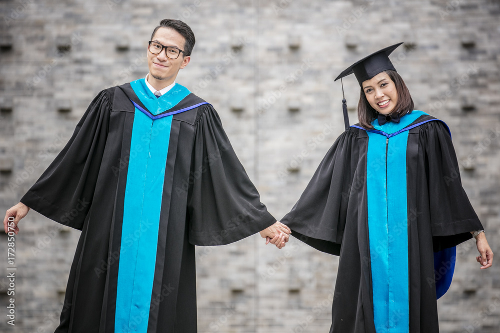 Two Asian graduates action with happiness in graduation day.