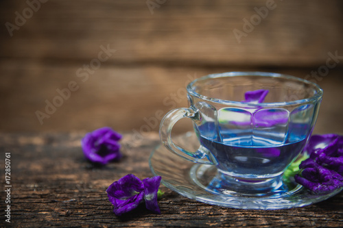 Violet flower Asian pigeonwings or Butterfly Pea Heabal hot drinking tea refresh Thai herb drink on wood background photo