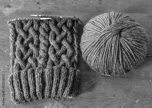 Homemade winter hat with intensive cable design in black and white.