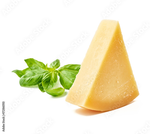 Parmesan cheese with basil leaves on white background. Italian cheese slices. photo