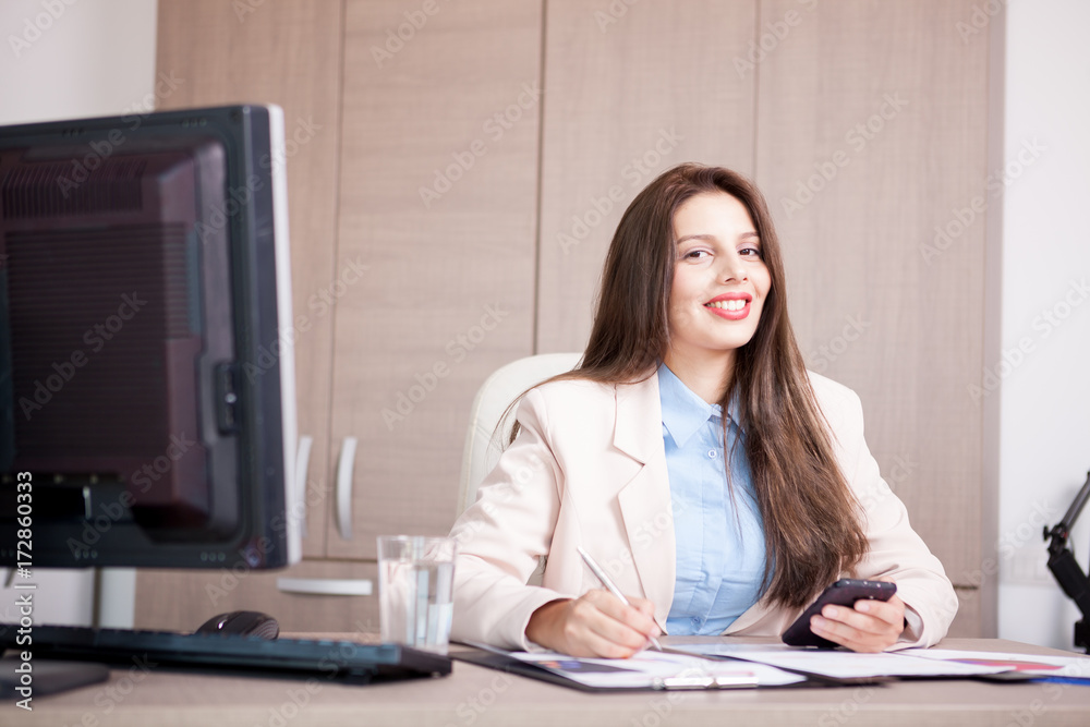 Smiling Young professional businesswoman working in the office. Business and marketing Smiling Young professional businesswoman working in the office. Business and marketing
