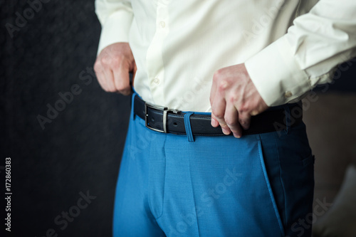 man putting on a belt, Businessman, Politician, man's style, male hands closeup, American businessman, European businessman, a businessman from Asia, People, business, fashion and clothing concept © bondvit