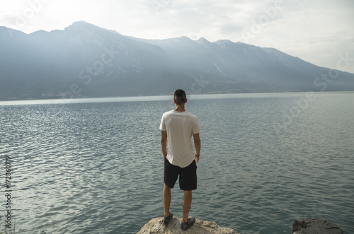 Boy thinking on a panoramic point over the lake