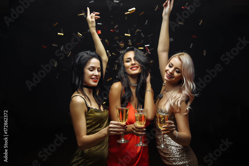 Young attractive women celebrating a party, drinking champagne and dancing