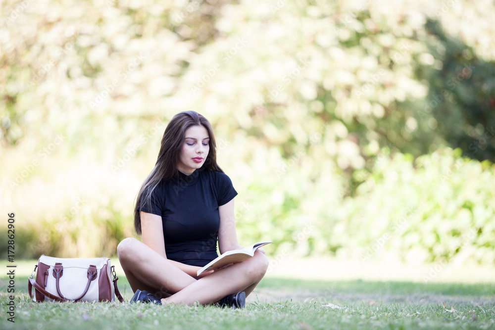 Gorgeous beautiful young woman reading a book in the pak. Person enjoying reading outdoor Gorgeous beautiful young woman reading a book in the pak. Person enjoying reading outdoor