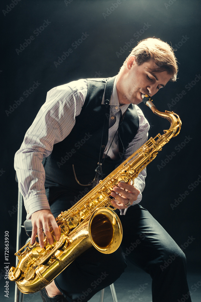 Naklejka premium Young man playing the Saxophone