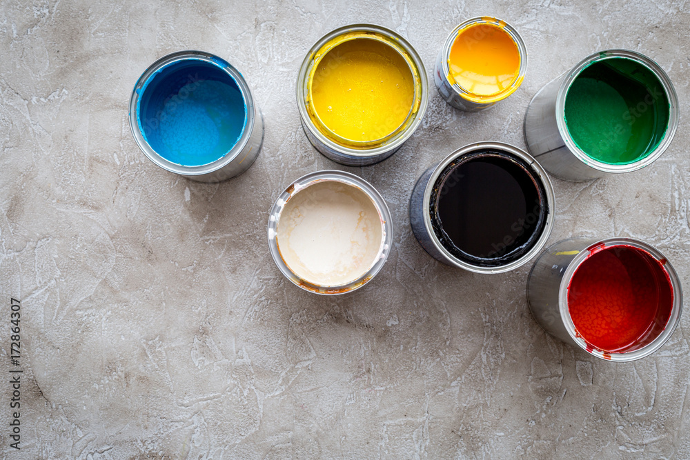 Paints in tin banks on grey stone background top view copyspace Paints in tin banks on grey stone background top view copyspace