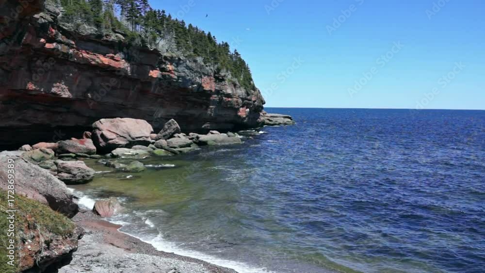 Cove beach in Bonaventure Island in Quebec, Canada in Gaspe, Gaspesie region with two grey seals, cliffs, waves washing ashore Cove beach in Bonaventure Island in Quebec, Canada in Gaspe, Gaspesie region with two grey seals, cliffs, waves washing ashore