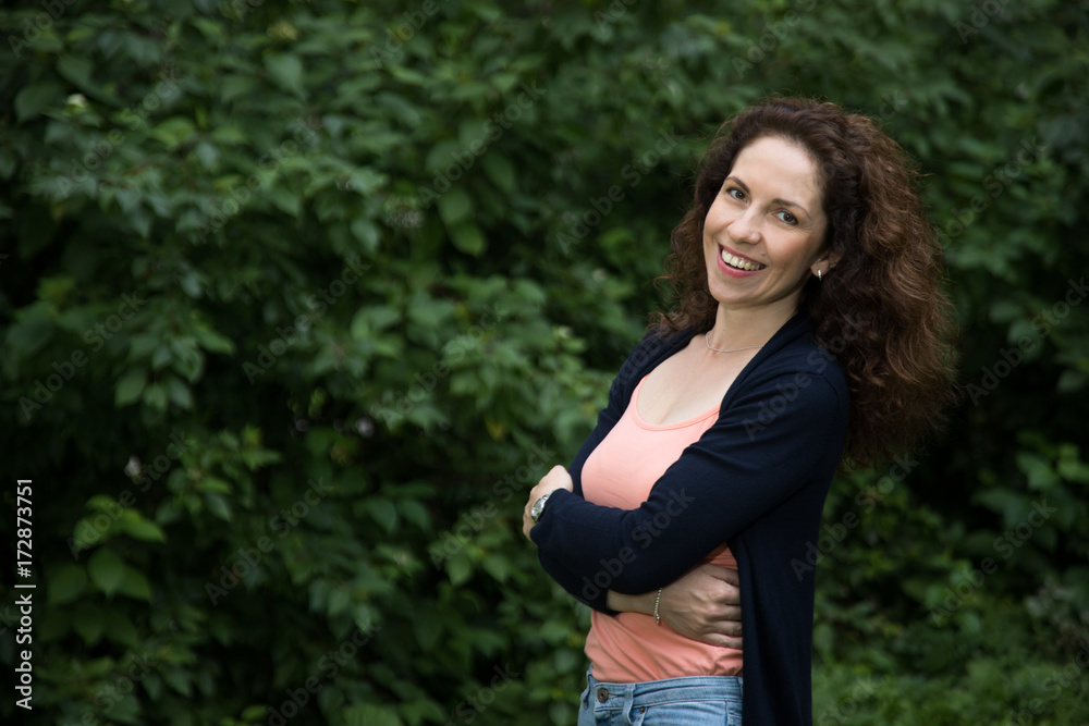 A portrait of a young smiling woman with a green background A portrait of a young smiling woman with a green background