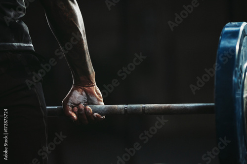 Close-up of a man's hand lifting barbell photo