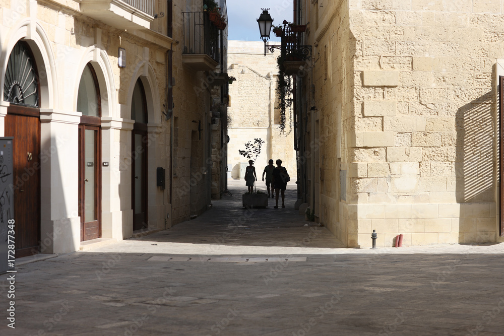 Tourists on a narrow street of an ancient city. Lecce, Apulia, Italy