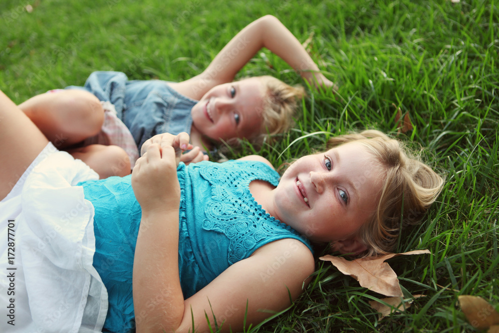 Sisters Laying In Grass Laughing Sisters Laying In Grass Laughing