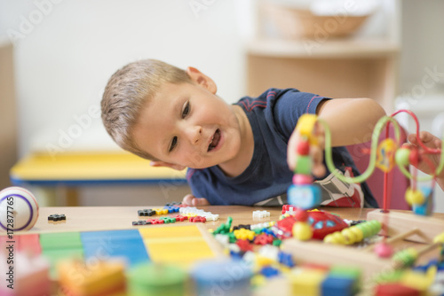 Smiling caucasian boy curiously looks in toy
