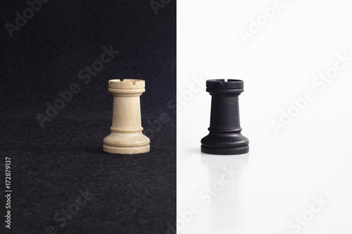 Pair of tower chess peaces confronted as opposites in black and white background