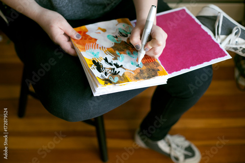 Artist creating colorful art on messy table