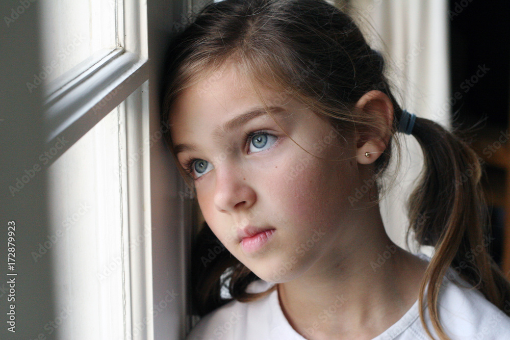 Girl With Pigtails Leaning Head Against Window Looking Out Stock Photo |  Adobe Stock