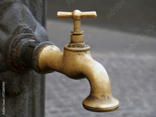 old vintage brass tap outdoors on iron post