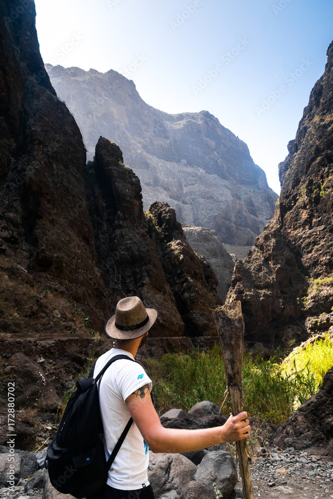 young hipster traveller hiking through Masca Valley, Tenerife Island