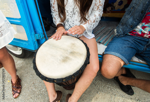close up of hippie woman playing tom-tom drum