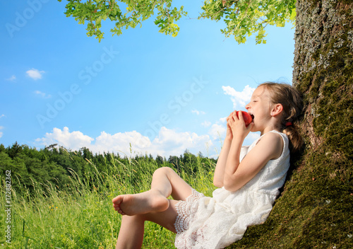 Obraz na plátně young girl sit next to a tree and smile into the summer sun