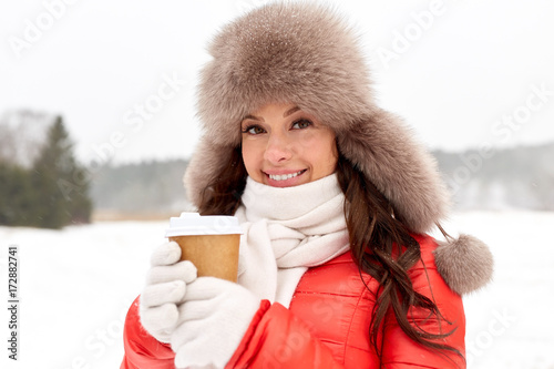 happy woman in winter fur hat with coffee outdoors © Syda Productions