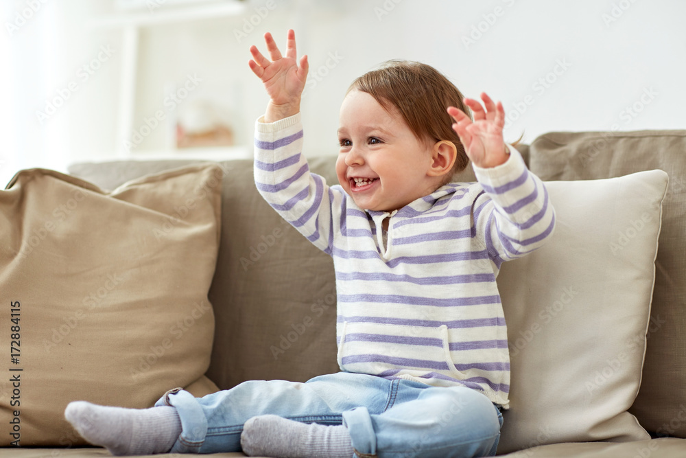 happy smiling baby girl sitting on sofa at home happy smiling baby girl sitting on sofa at home