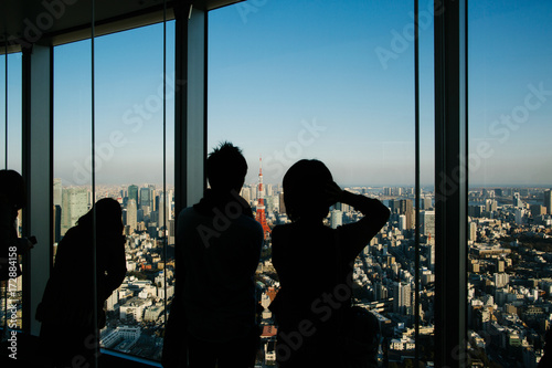 Silhouette of Tourists Looking at Tokyo Cityscape from Skyscraper Viewpoint photo