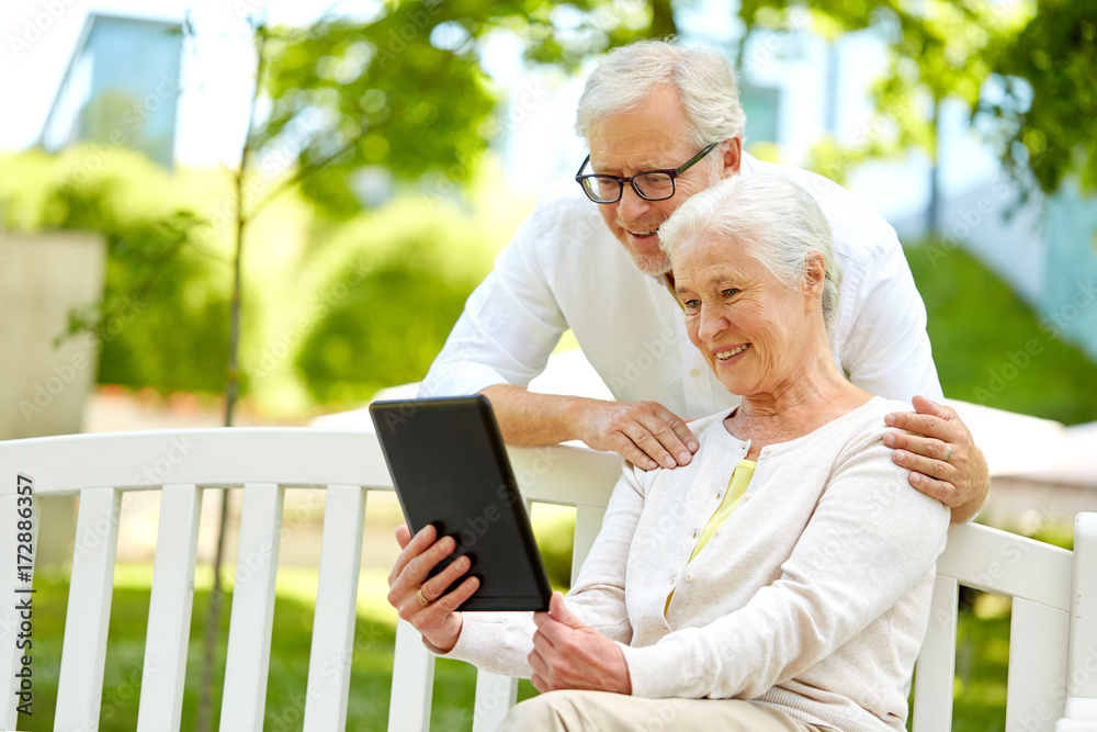 happy senior couple with tablet pc at summer park happy senior couple with tablet pc at summer park