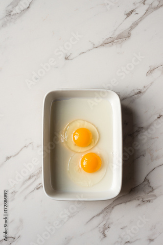 two raw eggs in a rectangle dish photo