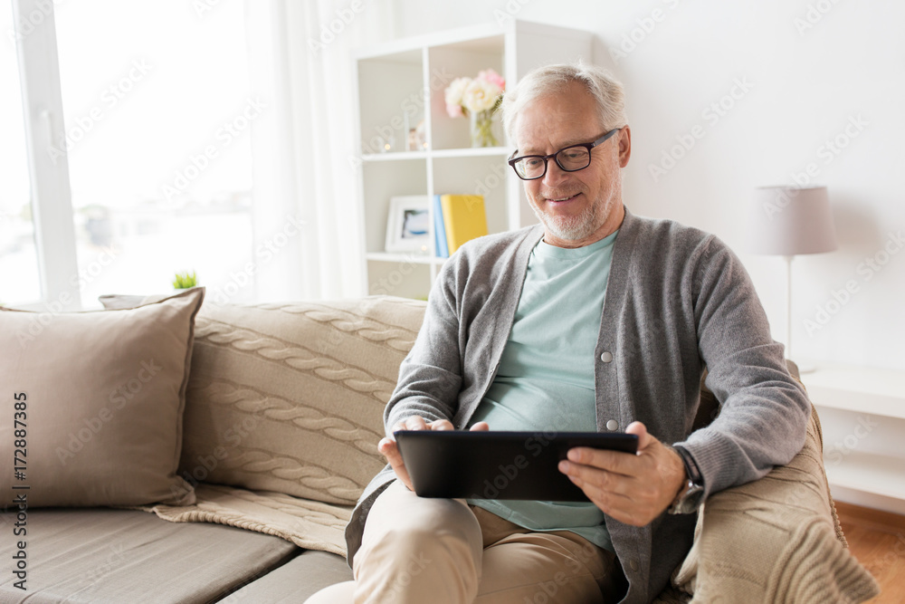 senior man with tablet pc sitting on sofa at home senior man with tablet pc sitting on sofa at home