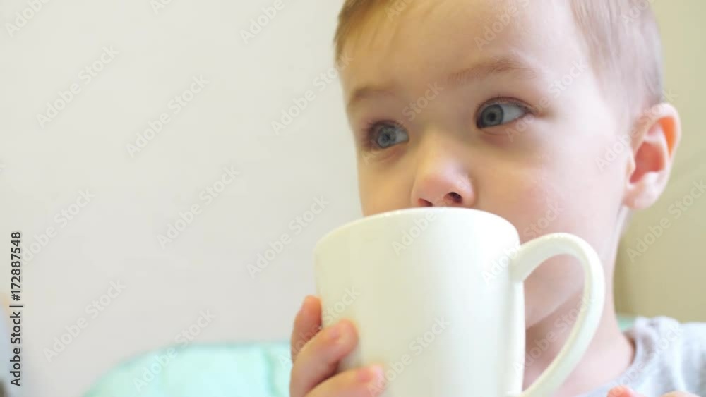 Little boy drinking tea in the kitchen Little boy drinking tea in the kitchen