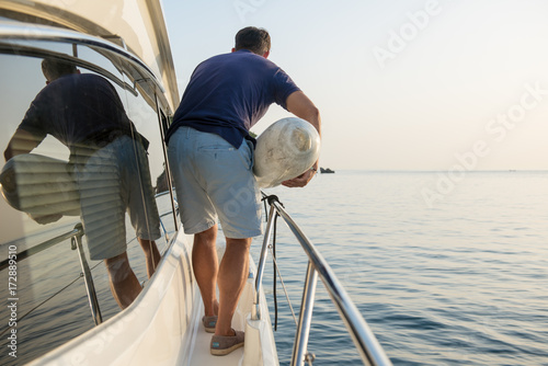 crew is holing a fender on boat