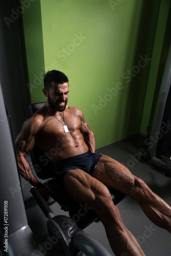 Man Doing Seated Leg Curls Exercise in Gym © Jale Ibrak