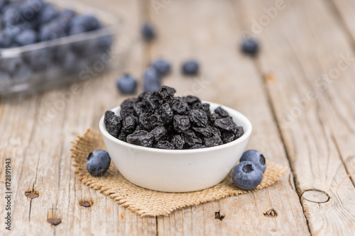 Portion of Dried Blueberries on wooden background, selective focus