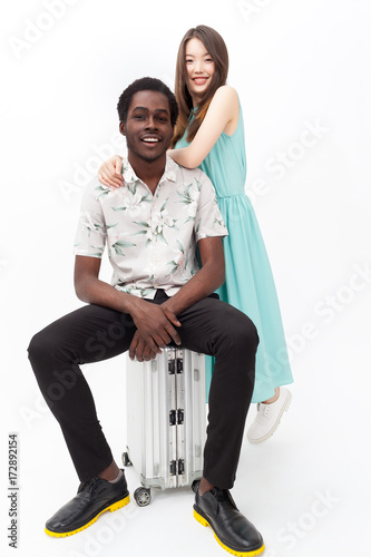 Happy couple of tourists with a suitcase