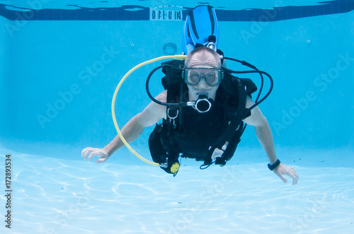 Scuba Diver hovering midwater in a pool. photo