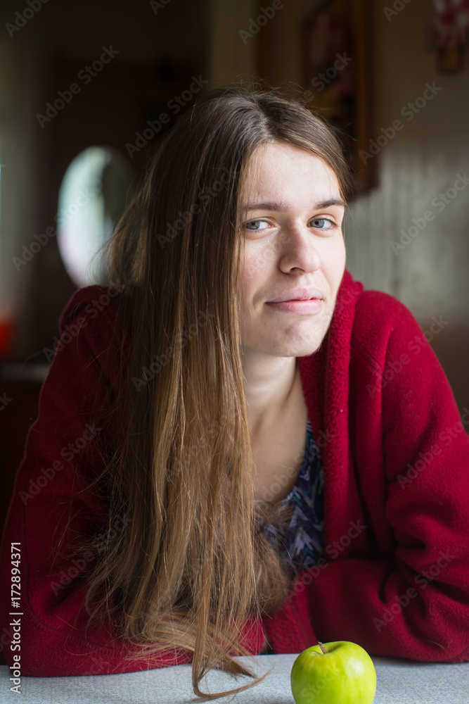 Portrait of young beautiful long-haired woman with apple in a red jacket.