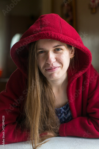 Portrait of young beautiful woman in a red jacket with hooded.