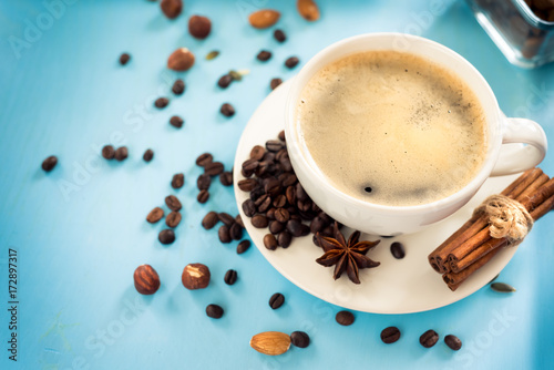 Cup of fresh coffee on blue wooden background, top view