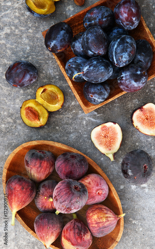 Fresh plums and figs on the wooden plates