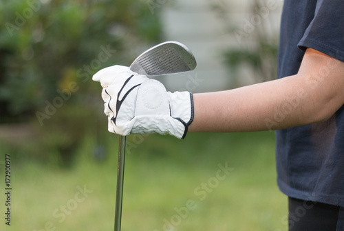 Golfer wearing white glove holdiing golf club