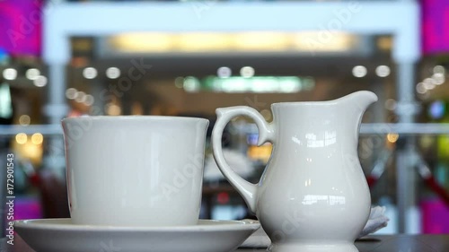 A cup of coffee and a milkman on a table in the cafe business center photo