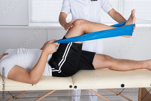 Physiotherapist Helping Patient While Exercising photo