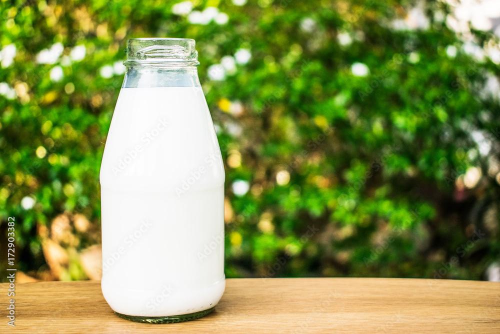 A bottle of milk on wood table. A bottle of milk on wood table.