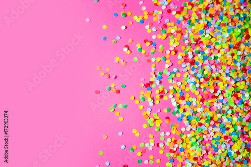 Frame made of colored confetti. Pink background.
