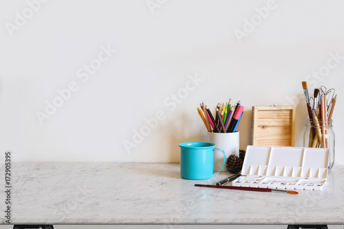 Work space Artist or designer Mock up : Desk space  or tabletop with brush, color pencil and craft tools. desk with copy space for products display montage. photo