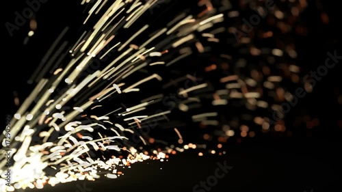 Animated realistic sparks bursting and flying in dark space as if cutting or girding metal. Motion blur and shallow depth of field. photo