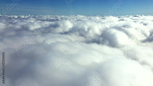 Aerial view flying over a layer of textured puffy clouds